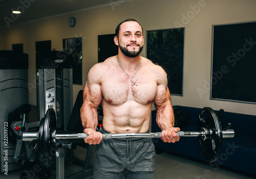 Bearded man is training in the gym with weights. Handsome guy is doing exercises for good muscles. Fitness personal trainer is at work. Sport motivation healthy lifestyle. Fit bodybuilder.