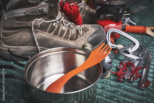 camping gear including boots, cooking utensils, and matches