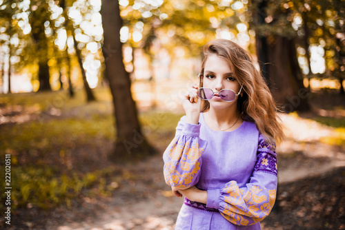 Portrait of cheerful Ukrainian girl wearing national embroidered shirt. Autumn portrait of cute curly teenage girl.