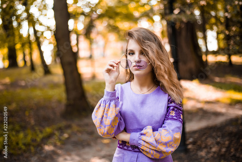Portrait of cheerful Ukrainian girl wearing national embroidered shirt. Autumn portrait of cute curly teenage girl.