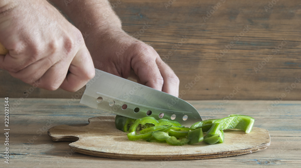 Φωτογραφία Slicing sweet green pepper bell on wooden cutting board