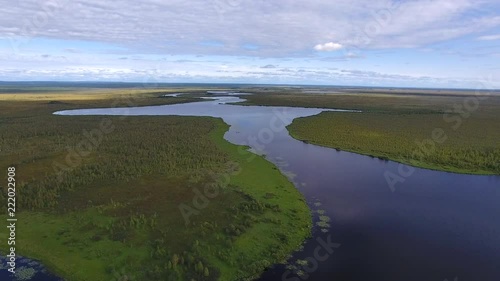 Flying over Northern Forest Lake.	Top view of the lake in the middle of the Northern forest. The camera flies over the taiga and a long lake