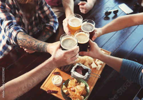 Fotografija Friends clinking glasses with beer in pub