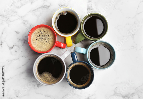 Many cups with tasty aromatic coffee on marble table, flat lay