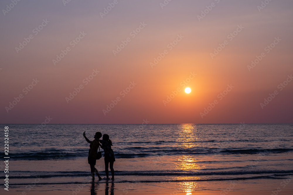 Couple taking selfie during sunset on the beach