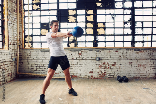 Caucasian Man Performs a Kettle Bell Swing for a Work Out