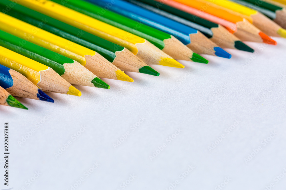 Fototapeta premium Color pencils on bright paper background, selective focus
