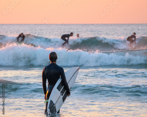 Canvas Print Surfer watching his friends surfing from the shore