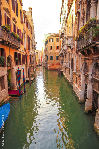 View on the historic architecture and the canal between the ancient buildings in Venice, Italy on a sunny day. © Spectral-Design