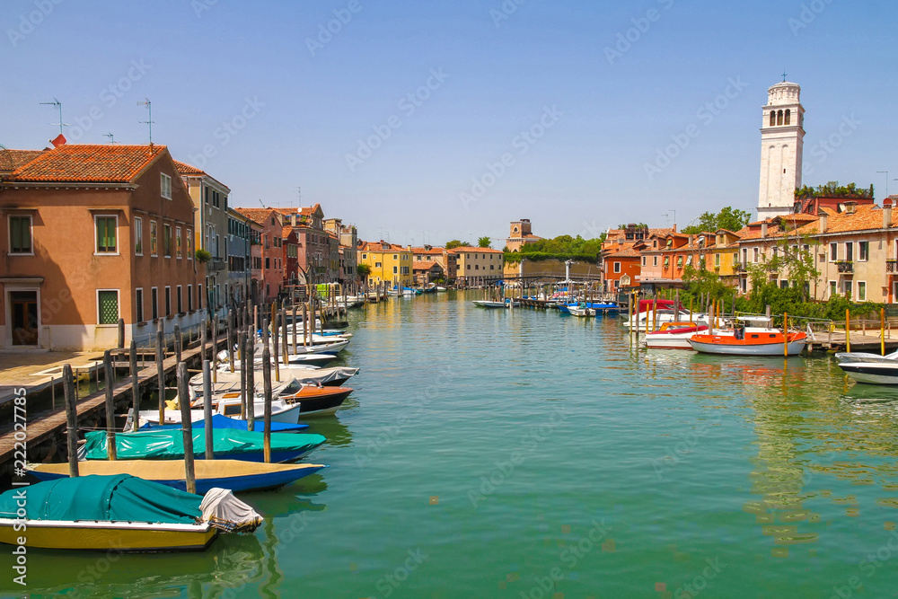Fototapeta premium View on the historic architecture and the canal between the ancient buildings in Venice, Italy on a sunny day.