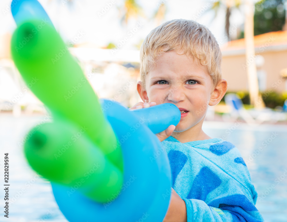 Φωτογραφία beautiful child plays with balloons at the edge of the pool, sunny day,close up