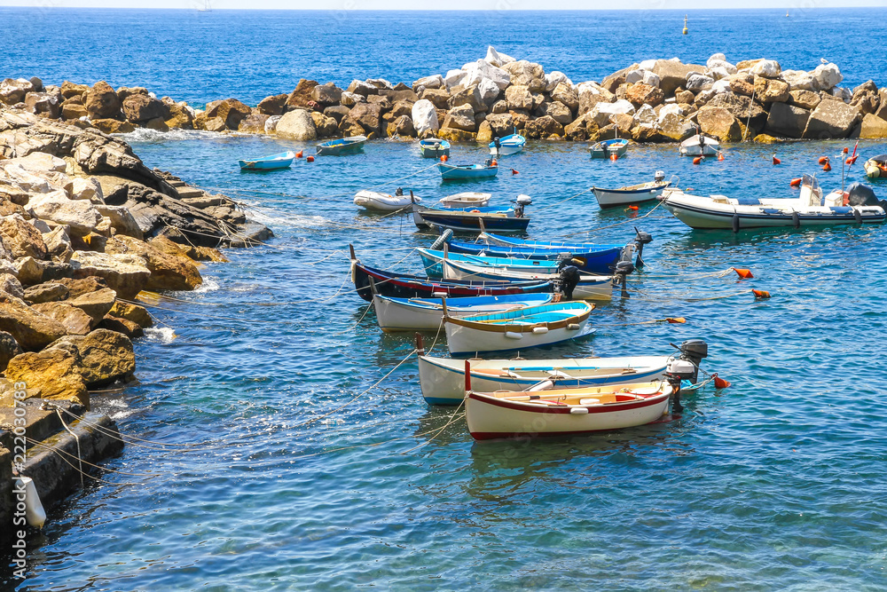 Fishing boats floating on the Mediterranean Sea in the harbour of Cinque Terre, Italy.