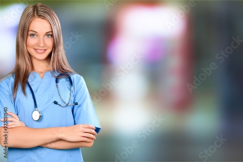 Attractive young female doctor with blurred hospital interior on