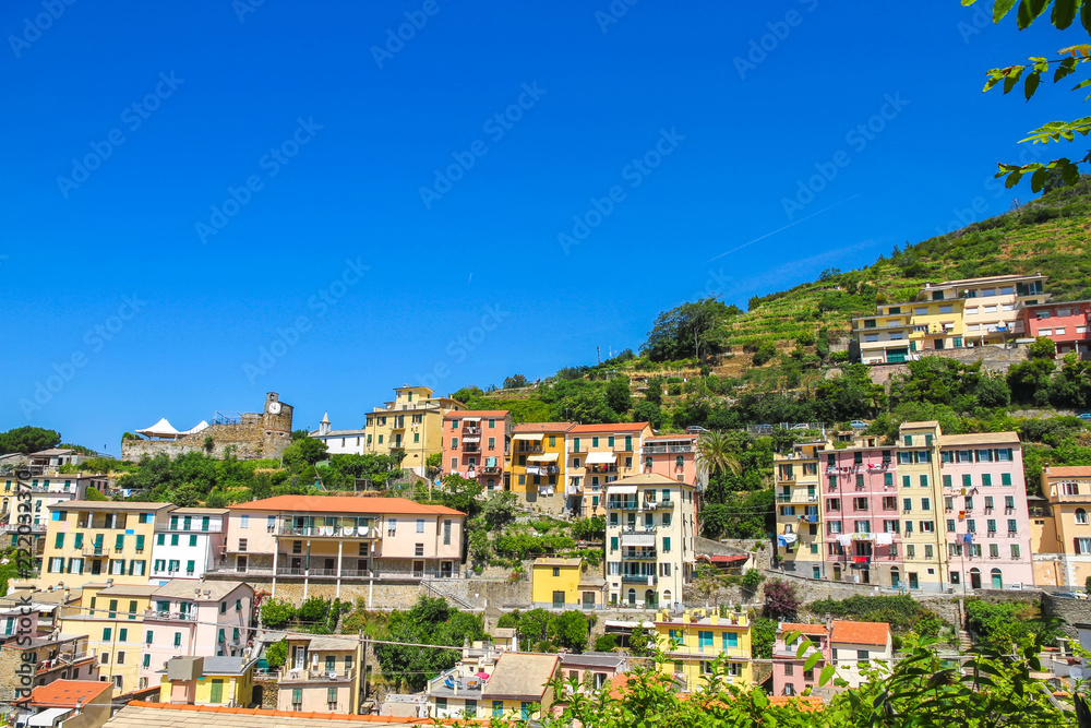 Naklejka premium View over the the historic architecture of Cinque Terre, Italy with colourful houses on a sunny day.