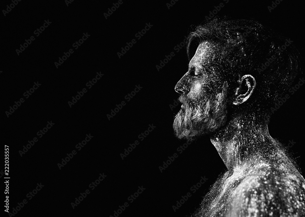 Fototapeta premium Concept. Portrait of a bearded man. The man is painted in ultraviolet powder.