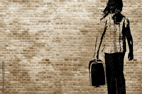 Graffiti/shadow on a brickwall showing a refugee girl walking with her suitcase