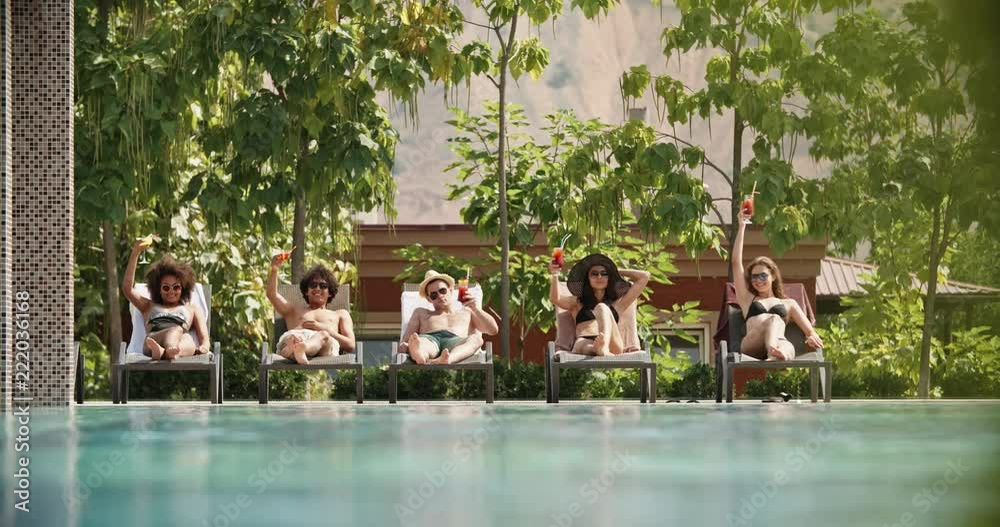 Group of five friends laying on chaise lounges, relaxing and drinking cocktails - vacation, lounge 4k