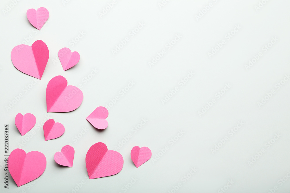 Pink paper hearts on grey background