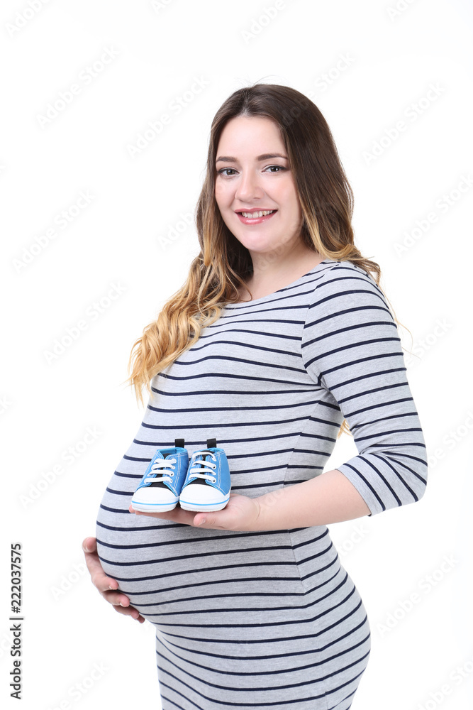 Beautiful pregnant woman with baby shoes on white background Beautiful pregnant woman with baby shoes on white background