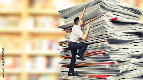 Businessmen climbing up a pile of documents on backround photo