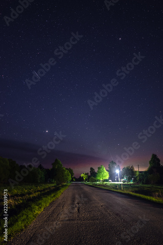 Starry sky over the road in the village