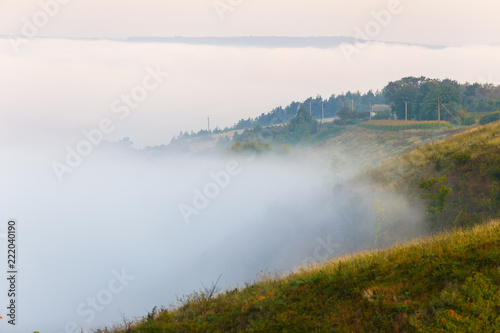 Thick fog covering green slopes in Ukraine. Morning landscape