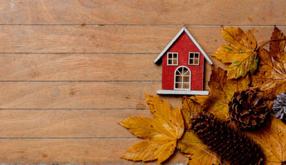 little vintage house with maple leaves on wooden table. Above view