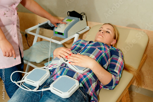 The doctor does the patient's electro-magnetic treatment procedure in the clinic. Close-up. Rehabilitation.