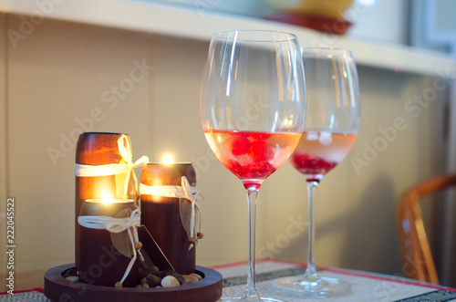 Glass with champagne and lighted candles, close-up. A place to relax.