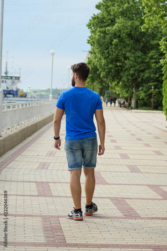 a young athletic man with beard walks along the waterfront a young athletic man with beard walks along the waterfront