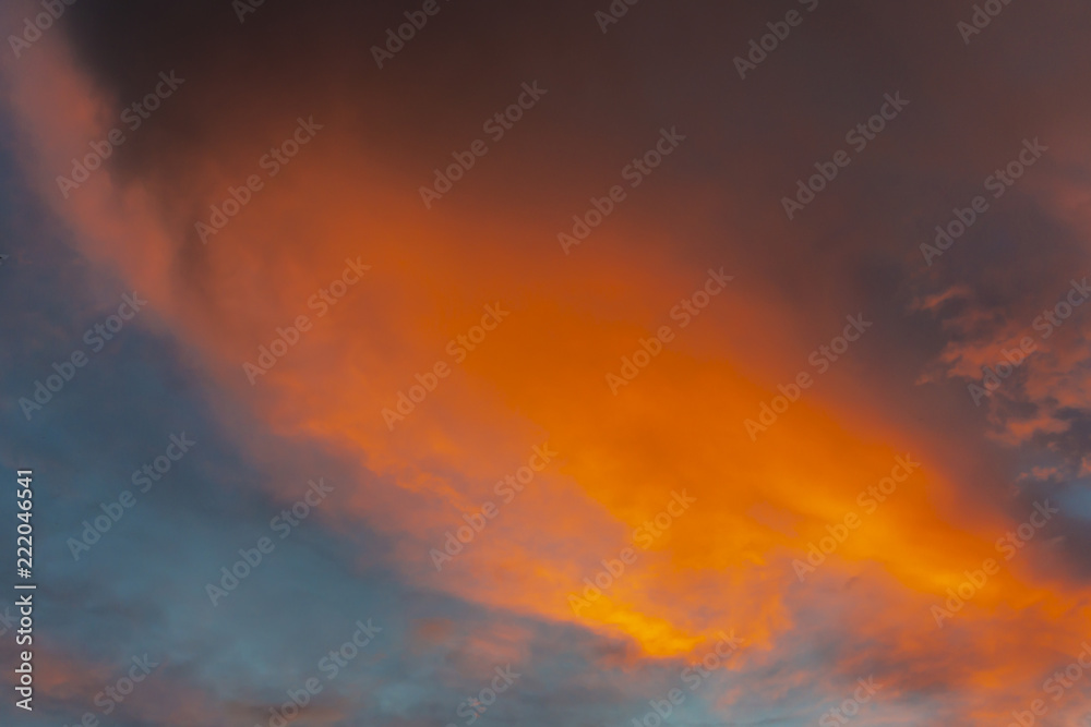 Blue sky at sunset with colorful clouds. Blue, blue, orange, gray, black and purple colors of the sky and clouds. Nature concept for design
