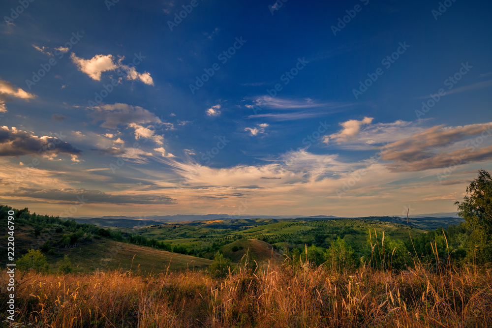Beautiful view over the picturesque hills with a sky full with beautiful clouds at sunset
