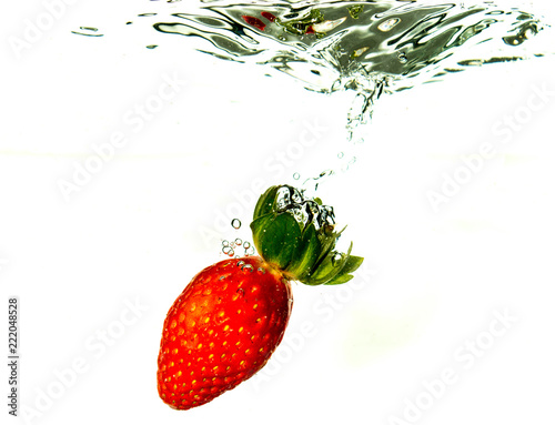 Strawberry dropped into liquid for artistic shot