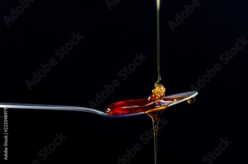 Golden maple syrup dropped onto a spoon