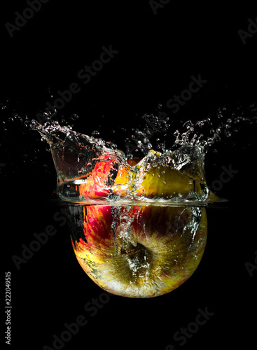 An apple dropped into liquid creating a beautiful splash