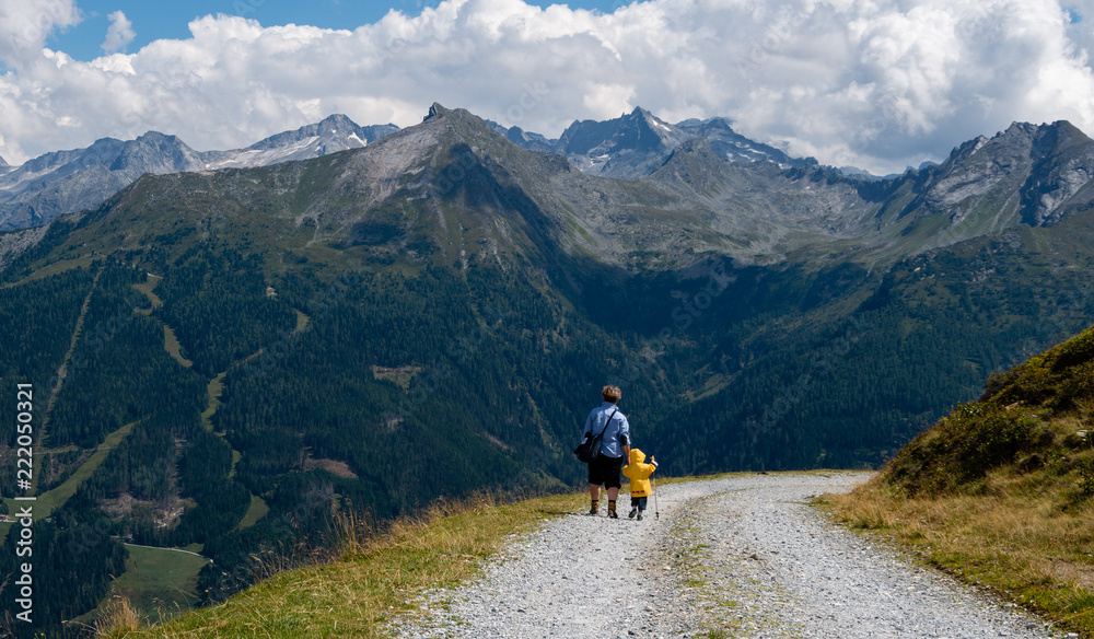Grandma and boy walking on mountain in Alps