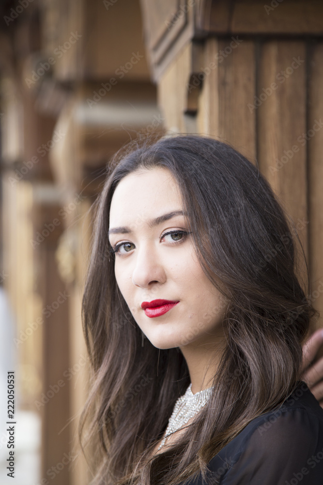 wooden window and beautiful woman. Portrait of fashion serious beautiful woman is wearing black dress near wooden wall with window wooden window and beautiful woman. Portrait of fashion serious beautiful woman is wearing black dress near wooden wall with window