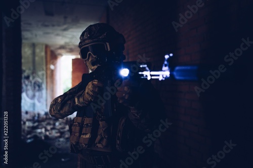 Peacekeepers in helmets and balaclava, holding an assault rifle pitselivaetsya at night in the dark