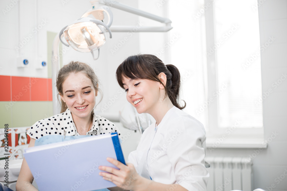 Fototapeta premium Dentist in white uniform with customers view the results of the survey in the dental clinic