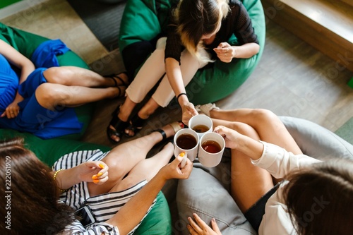 Employees of the Corporation drink coffee sitting on a bean bag in the office, top view