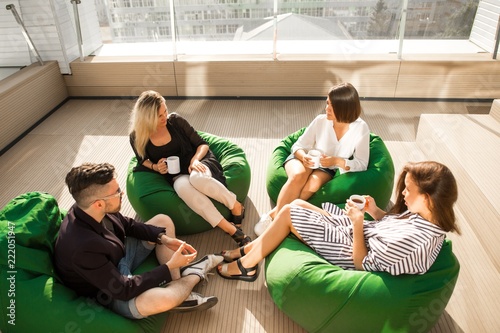 Bild auf Leinwand Creative business team at the break sitting on the green bean bag on the terrace