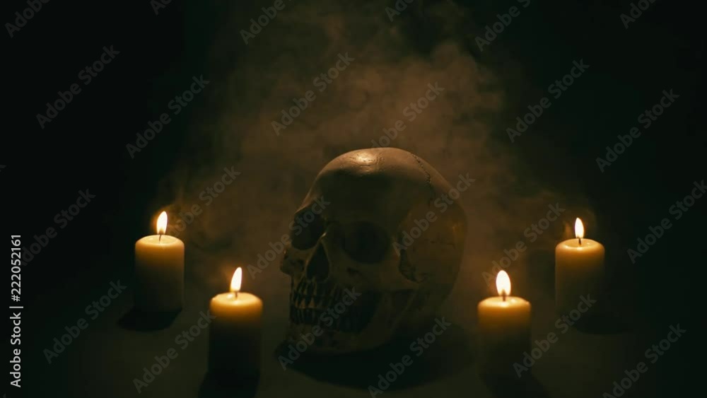 Skull between candles with smoke, halloween theme Skull between candles with smoke, halloween theme