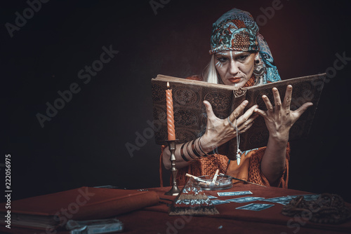 Slika na platnu Folklore gypsy tribal soothsayer, chanting spell from her spellbook