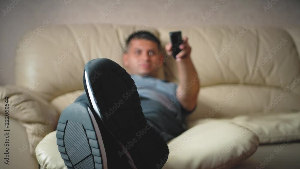 Home, people, technology and entertainment concept, man with remote control watching tv at home. Home, people, technology and entertainment concept, man with remote control watching tv at home.