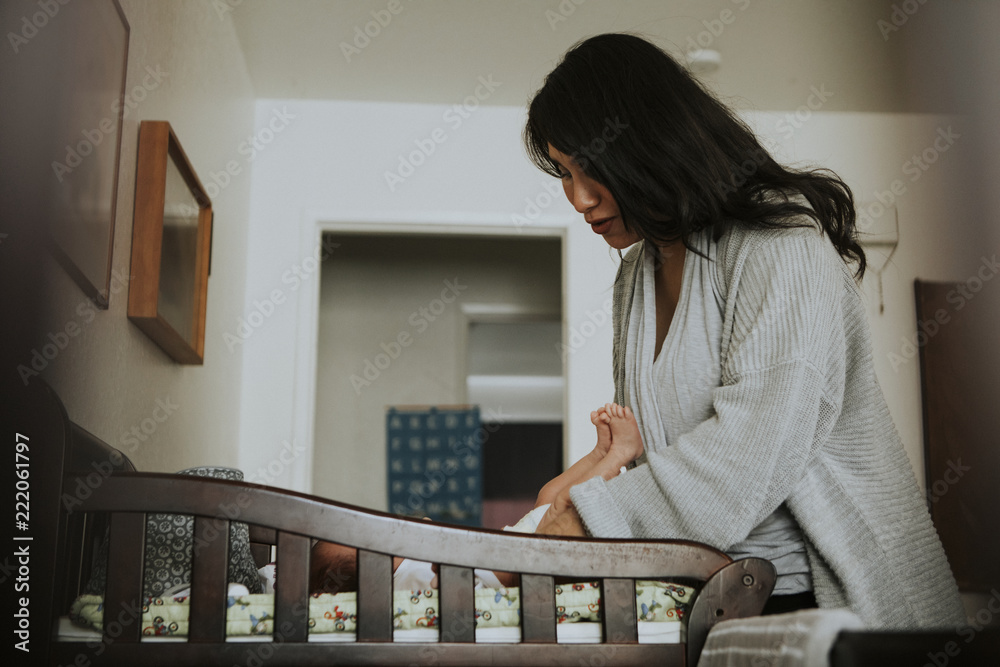 Mother changing a diaper on a newborn baby Mother changing a diaper on a newborn baby