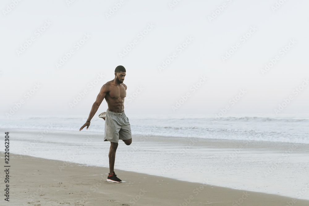 Fit man stretching at the beach