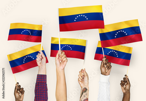 Hands waving flags of Venezuela photo