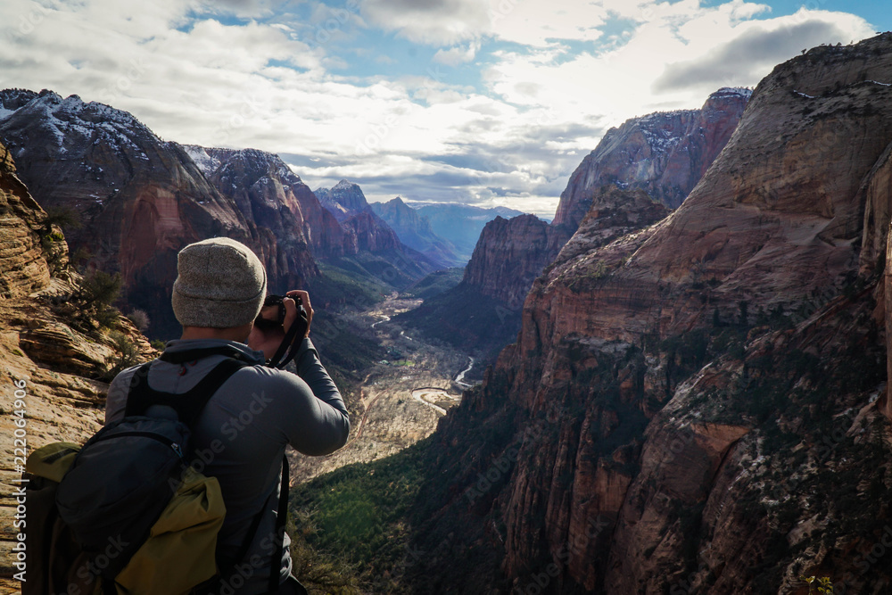 Fototapeta premium Adventure photographer capturing the valley of Zion National Park from atop of Angels Landing