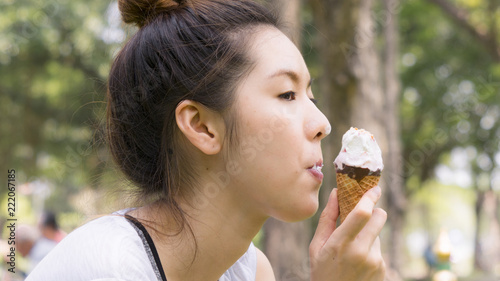 cute girl eat ice cream in close up face feeling delicious photo