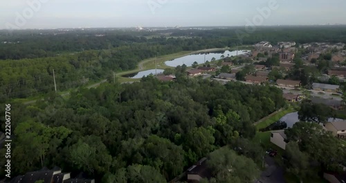 Aerial shot of Kissimmee, Florida. Drone flies over houses and forests. In the distance some lakes are visible. photo